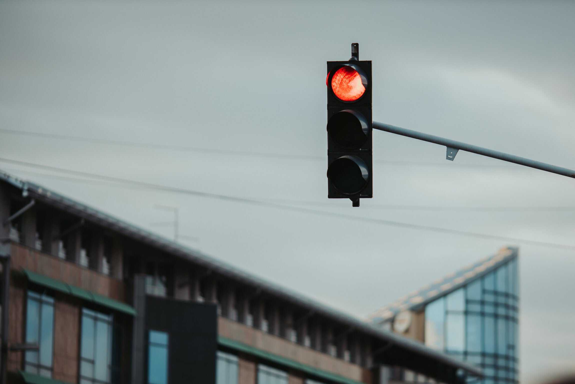 Red traffic stoplight with blurred city bacground.