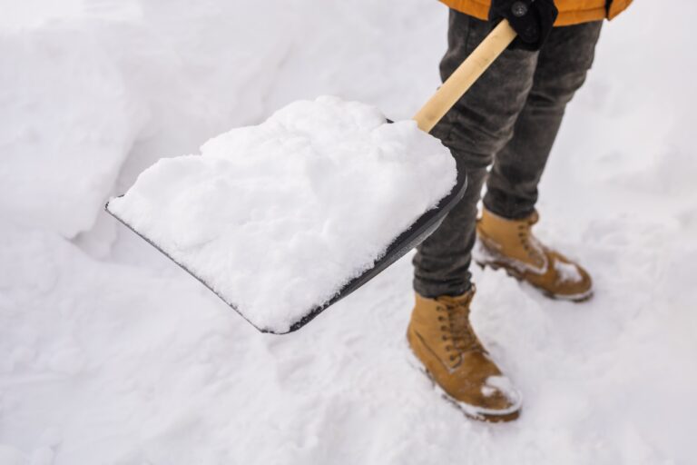 Man cleaning snow from sidewalk and using snow shovel. When Do Virginia Premises Liability Cases Usually Occur concept