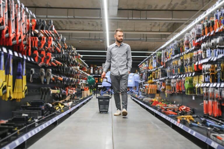 male builder in a hardware store. Falling objects in store concept.